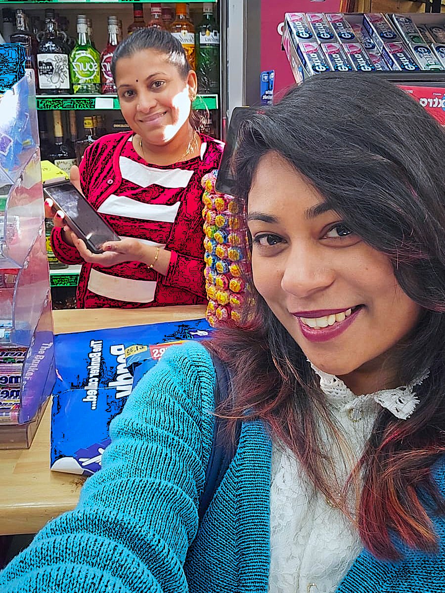 Happy with a shop owner behind the counter of a convenience store