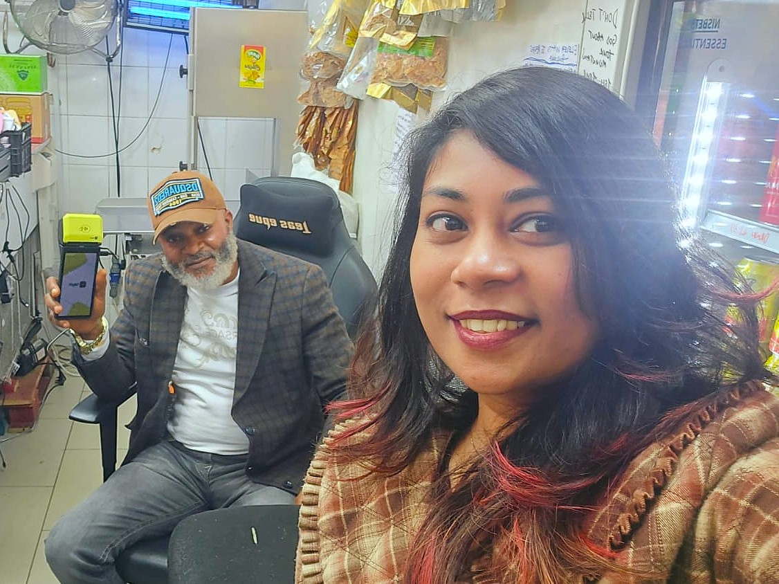 Happy with the owner of a barbershop, card terminal in hand